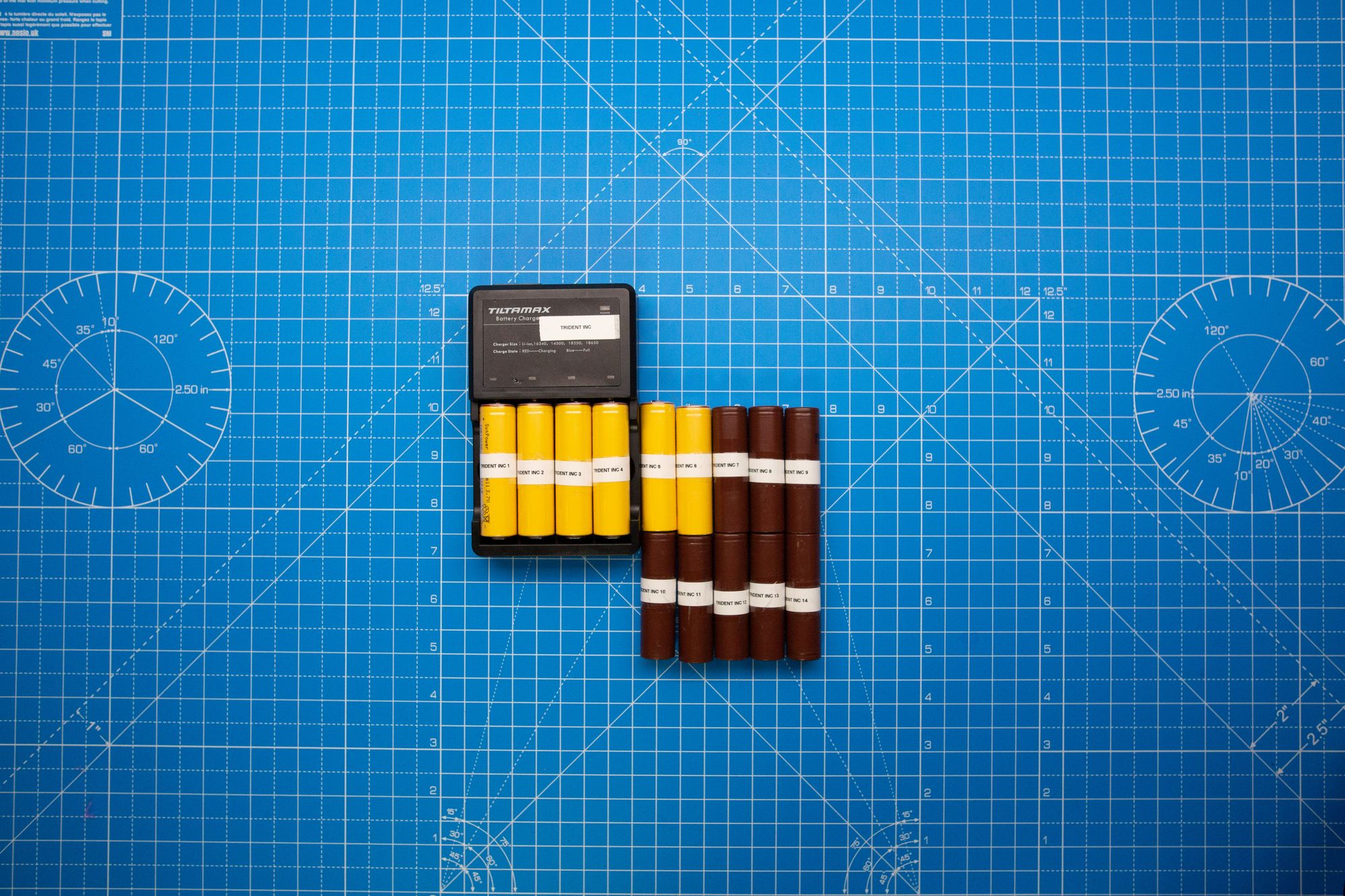 Batteries and a charger arranged on a blue surface