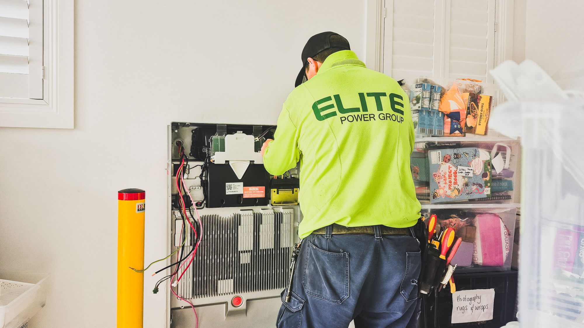 A technician installing a home battery system indoors