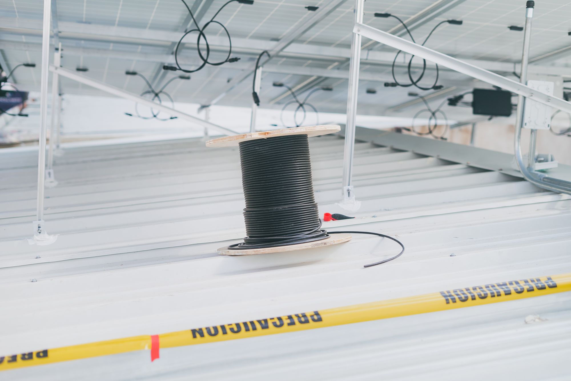 Coiled cable on a rooftop beside solar panels