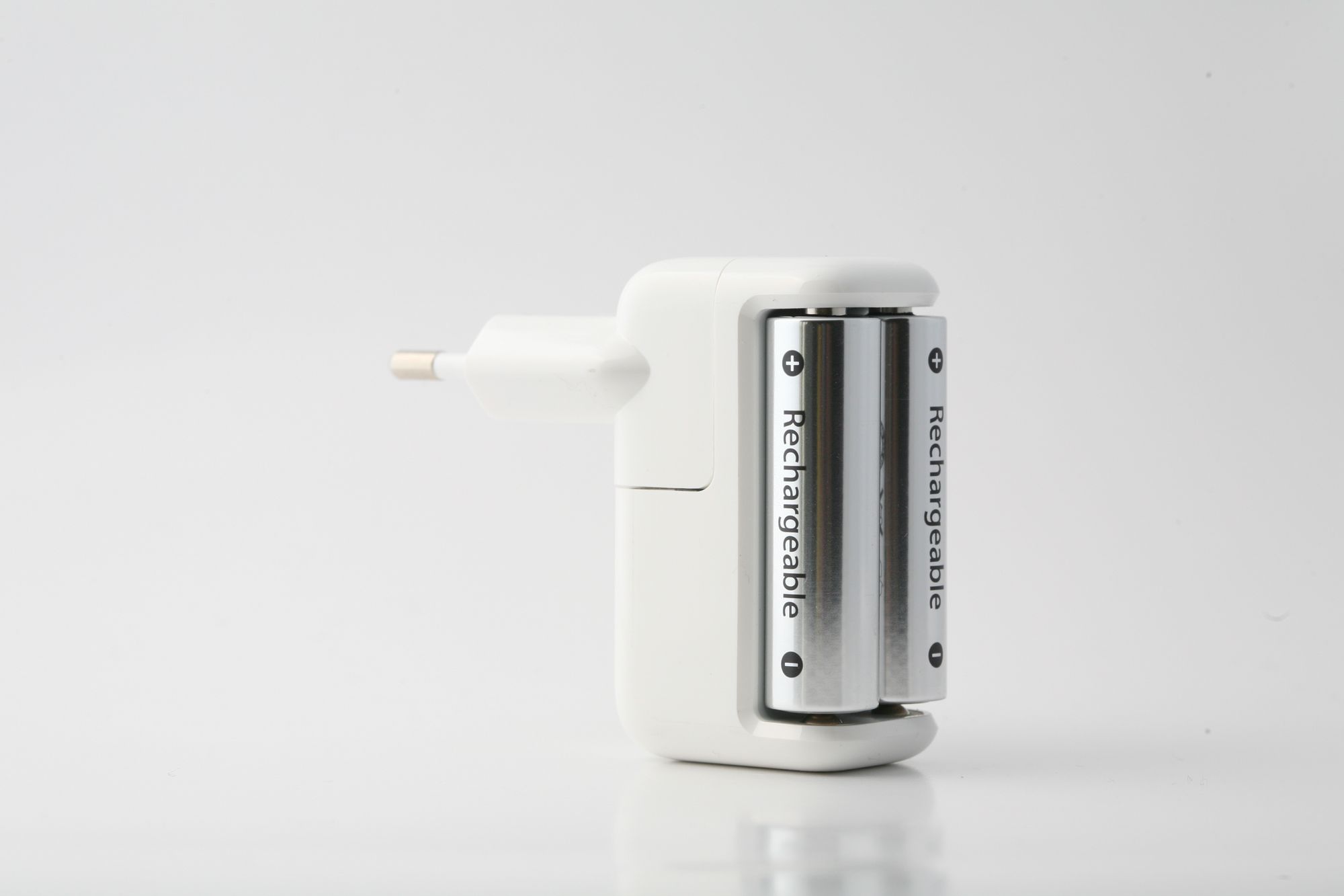 A rechargeable battery charger with two batteries on a white surface